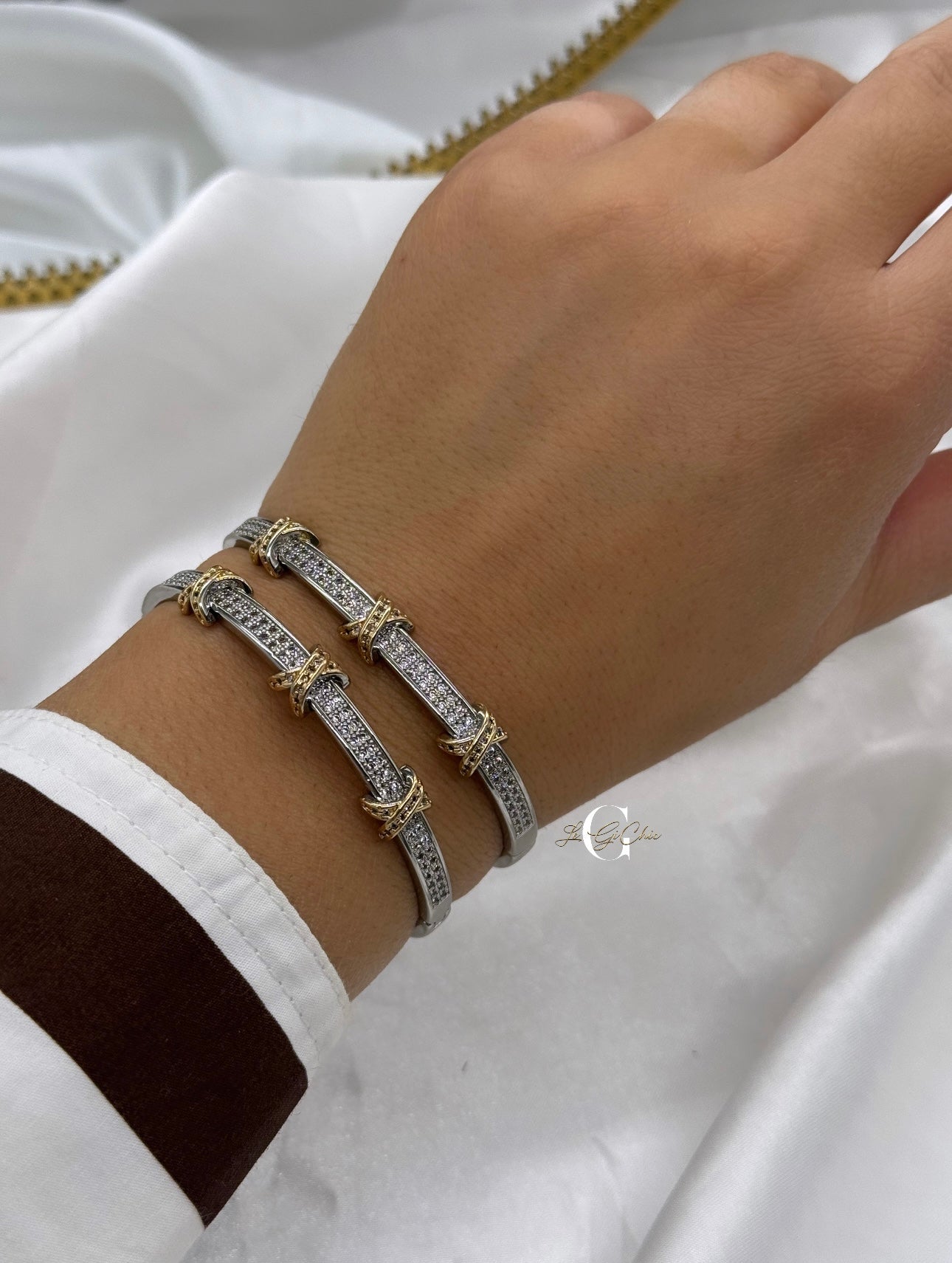 Bracciale “rigido con fascia di zirconi e incroci oro”