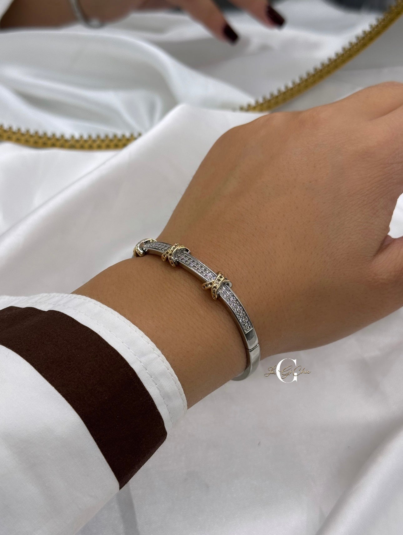 Bracciale “rigido con fascia di zirconi e incroci oro”