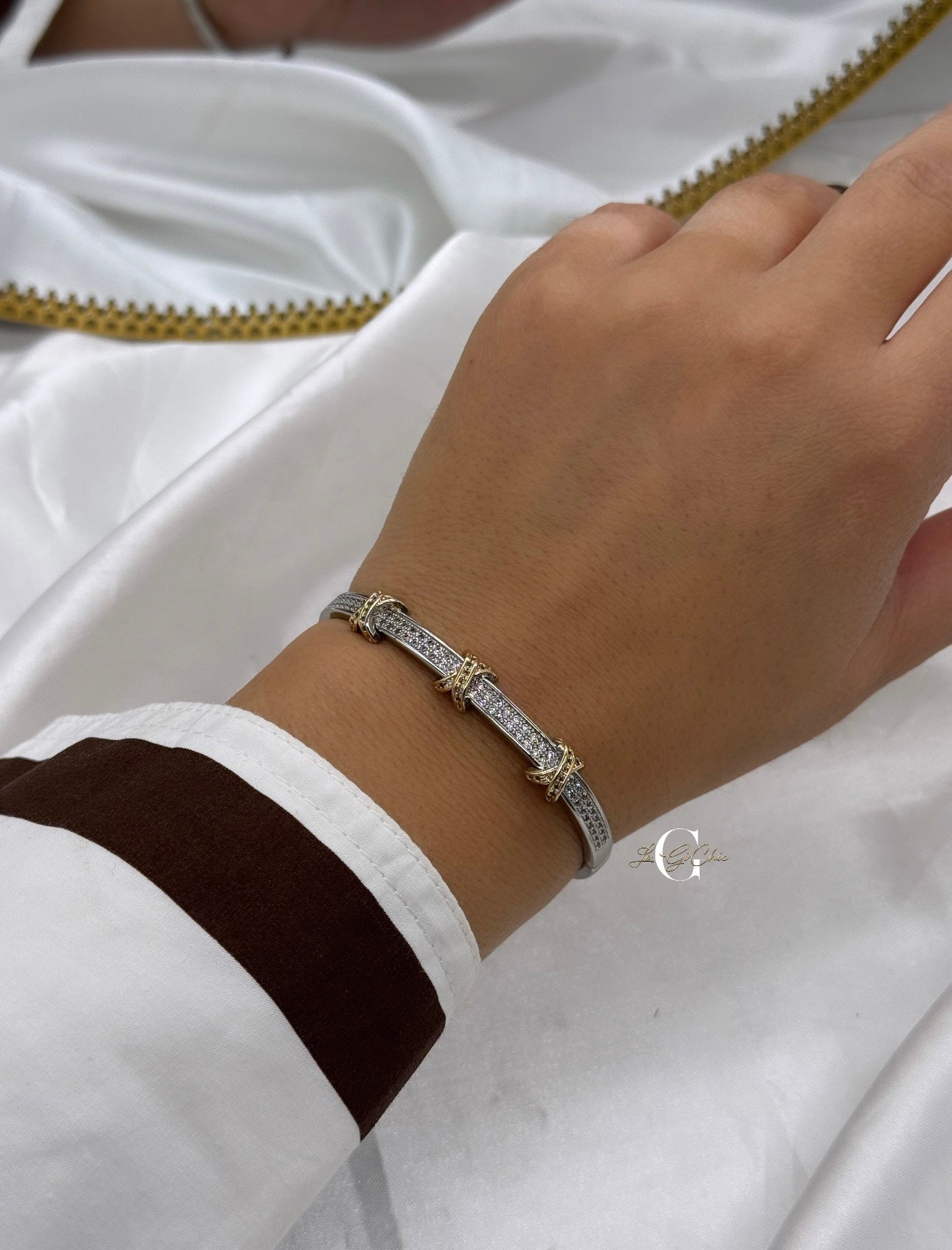 Bracciale “rigido con fascia di zirconi e incroci oro”